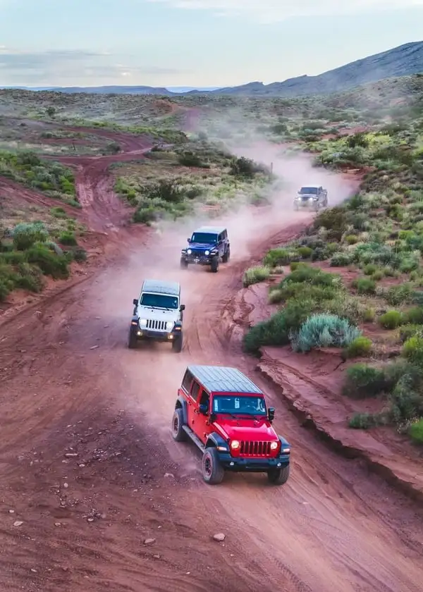 Jeeps in the dust driving fast on a trail